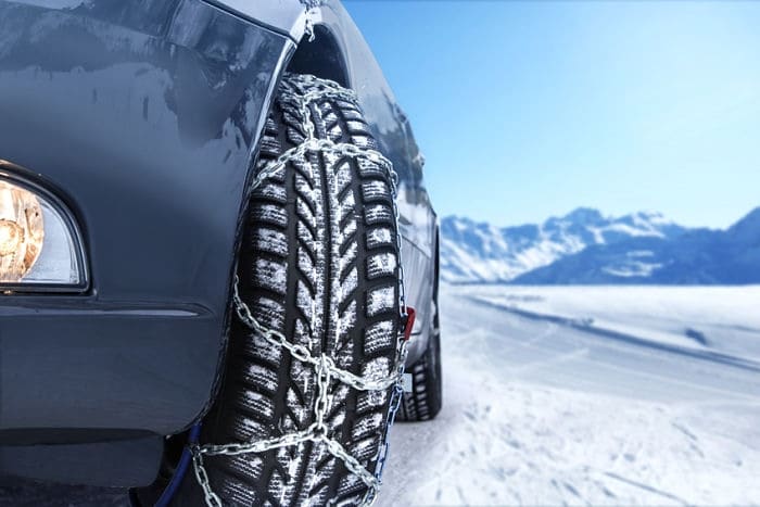 Car with mounted snow chains in wintry environment