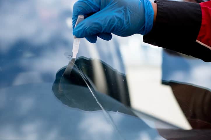 Man carrying out repairs to a car windscreen