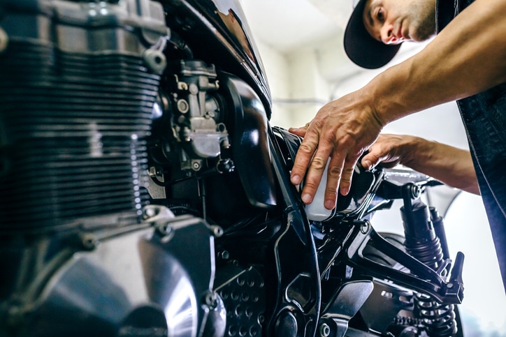 Mechanic repairing customized motorcycle in the workshop