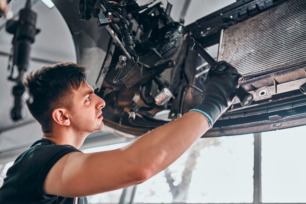 mechanic looking under chassis